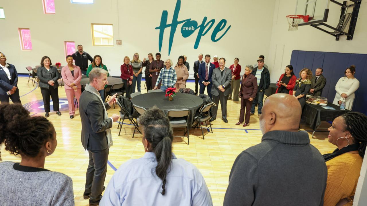 Ohio State President Carter addresses a group of people in a gymnasium. 